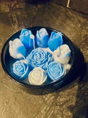 Handgjort dekorationsljus i skål – blå vaxblommor (doftfri) - Säljer ett handgjort dekorationsljus i skål, där skålen är fylld med vax och ovanpå är det dekorerat med vaxljus i blomform i olika nyanser av blått. Väldigt fint som inredningsdetalj, present eller till dukning. Handgjort Färg: flera blå nyanser Mått: ca 15 cm diameter, ca 7 cm höjd  