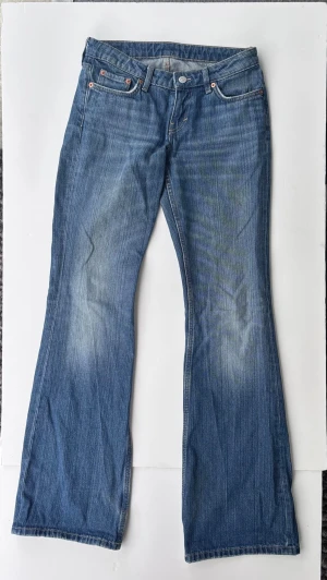Weekday Nova Low Slim Bootcut Jeans - Snygga low waist blå bootcut jeans från Weekday i modellen Nova Low Slim Bootcut. Perfekta med ett par boots eller sneakers.         L34 W26