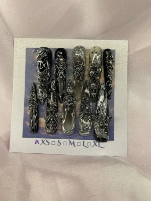 Relix (XS);ExtraLongSlimStiletto - Unika handgjorda press-on naglar i svart och silver med 3D-effekt och abstrakt mönster. Naglarna är extra långa och spetsiga, perfekta för dig som vill sticka ut. Designen är handgjord för en edgy look. Modell av är gjorda efter smala asiatisk stilettoform.