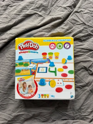 Play-Doh Shape & Learn Numbers Set - Play-Doh Shape & Learn Numbers & Counting är ett färgglatt lekset för barn från 2 år. Innehåller tre burkar modellera i olika färger, formar och tillbehör för att lära sig siffror och räkning på ett kreativt sätt. Perfekt för små händer och pedagogisk lek.