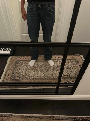 Levi's 505 blå straight jeans - Säljer ett par klassiska blå Levi's 505 jeans med rak passform och fem fickor. Jeansen har tydliga kontrastsömmar, bälteshällor och den ikoniska läderlappen bak i midjan. Perfekta för en avslappnad och tidlös stil. Storleken är 28/28