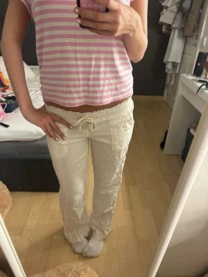 Roxy linnebyxor  - Säljer ett par vita linnebyxor med avslappnad passform och dragsko i midjan. Byxorna har raka ben och fickor framtill. Perfekta för en chill och bekväm stil. Materialet är luftigt linne som passar bra till sommaren.