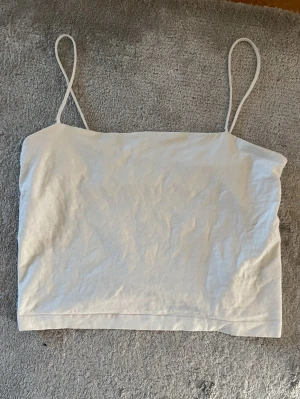 Vit linnetopp med tunna axelband - Säljer ett vitt linne med tunna axelband från Gina Tricot i strl L men skulle säga att den är mer som en M/S. Använd men i gott skick 🤍