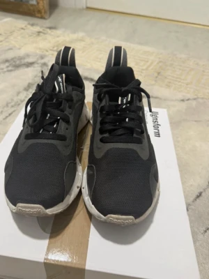 Svarta Reebok sneakers med mesh - Snygga svarta sneakers med vit, chunky sula och svart mesh-ovandel. Skorna har svarta snören och diskreta loggor på sidan och tungan. Låg modell med sportig vibe och coola detaljer på sulan.