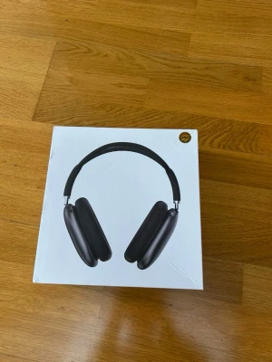 Apple AirPods Max svarta hörlurar - Snygga Apple AirPods Max i svart med en stilren design. Hörlurarna har stora, mjuka öronkuddar i tyg och metallbyglar med meshband för extra komfort. Perfekta för dig som vill ha grymt ljud och modern look.