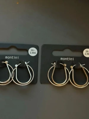 Silvriga creoler från Montini - 12kr för båda. Säljer två par silvriga creolörhängen från Montini. Örhängena har en klassisk rund form med en räfflad yta som ger extra glans. Perfekta för att lyfta vilken outfit som helst. Kommer på originalkort från Ur & Penn.