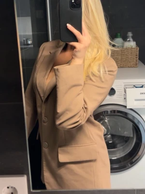 Beige oversized kavaj med fickor - Stilren beige kavaj i oversized modell med två knappar framtill och två framfickor. Klassisk krage och rak passform som ger en trendig look 🩷