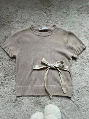 Beige stickad topp från Zara - kortärmad stickad topp från zara i beige med rund halsringning och ribbade kanter, inte nopprig och super fint skick