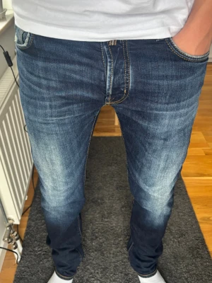 Jacob Cohën Nick (J622) Premium Denim - Handgjorda i Italien 🇮🇹 - Sjukt snygg blå tvätt med naturliga slitningar. En av Jacob Cohëns mest populära modeller, känd för perfekt passform och högkvalitativ japansk denim. Alla slitningar är original, handgjorda. 🧵 Märke & Modell: Jacob Cohën - J622 (nuvarande Nick). 📏 Storlek & Passform: W35. Slim straight  med modern passform och stretch för komfort. 📐 Mått: A 45 cm, B 82 cm, C 110 cm. ✅ Skick: 9/10. ✨ Handgjorda i Italien. 💰 Nypris:  4500-4000 kr. Skriv vid funderingar/fler bilder! ‼️Skickas samma dag/dagen efter‼️