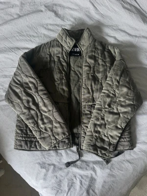 Quiltad grå/grön  jacka  - Quiltad vindjacka från Zara, andvänd flera gånger men inga tecken på slitage.❤️storlek L, liten i storleken så perfekt för någon som vanligtvis har M i storlek.