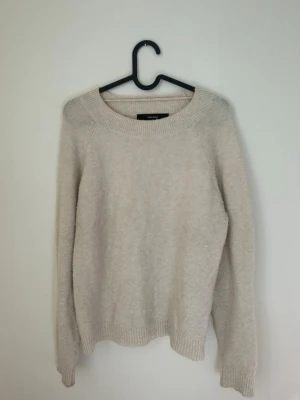 Beige stickad tröja  -  beige stickad tröja med rund halsringning och långa ärmar. Tröjan har ribbade muddar vid ärmslut och nederkant, perfekt för lager på lager. Enkel och stilren design som passar till det mesta.