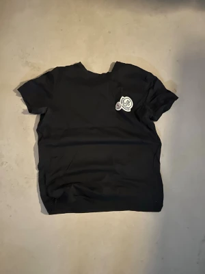 Moncler t-shirt - Svart Moncler t-shirt i storlek M. Mycket bra skick, lite skrynklig pga legat i garderoben ett tag. QR-kod och industrie tag är korrekt. Säljs för 3400kr på moncler hemsida, säljs för ca. 1300kr begagnad. 