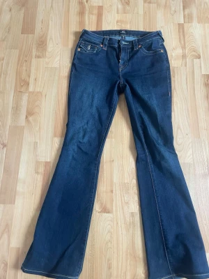 Mörkblå bootcut jeans från True Religion - Snygga mörkblå bootcut jeans från True Religion i modellen Becca. Strl 27 i midjan och uppsydda på Jeansbolaget för att passa mig som är 170 cm. Väldigt sparsamt använda så därför nästan nyskick. Nypris ca 1200. Skriv gärna vid frågor eller prisförslag💗
