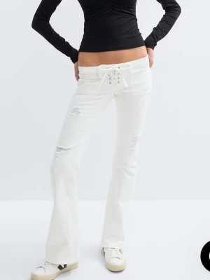 Vita bootcut jeans med snörning  - Säljer mina trendiga vita gina tricot jeans med snörning som är slutsålda i alla storlekar. Byxorna är i tall m. Jag är 170 och dem går ända ner till marken med skor på.