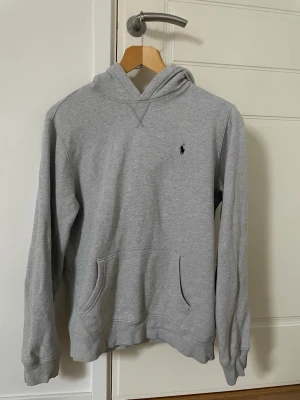 Grå hoodie från Polo Ralph Lauren - Klassisk grå hoodie från Polo Ralph Lauren med broderad logga på bröstet.skick 8/10 pris 500 de kan diskuteras.Ny pris 1000 .Storlek XL barn