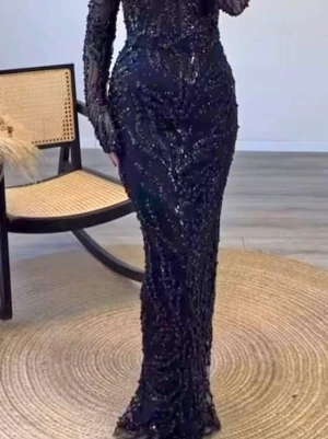 Glittrig långklänning med pärlor - Säljer två eleganta långklänningar med glittriga detaljer och pärlor. Ena klänningen är svart med lång ärm och figurnära passform, den andra är champagnefärgad med liknande design. Båda har transparenta partier och vackra mönster av pärlor och paljetter.