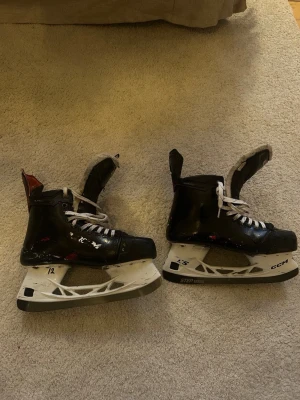 Svarta hockeyskridskor från CCM - Säljer ett par svarta hockeyskridskor från CCM med vita snören och silvriga Step Steel-skenor. Storlek 43,5