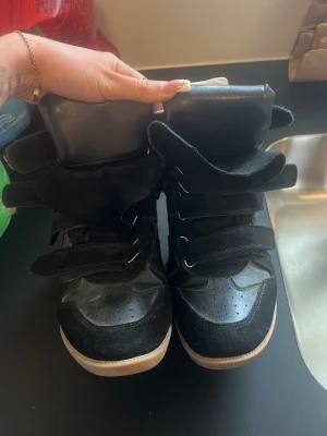Svarta high-top sneakers med kardborre - säljer isabel marant skor i storlek 39 1/2. har använts ett par gånger men är fortfarande i fint skick! säljer då dem tyvärr är för stora för mig.