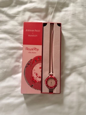 Audemars Piguet x Swatch Royal Pop - Snygg klocka från Audemars Piguet x Swatch, modellen Royal Pop Otto Rosso. Klockan har en röd boett med vita detaljer och ett ljusrosa armband. Levereras i originalförpackning med certifikat. Perfekt accessoar för dig som gillar färg och unik design.