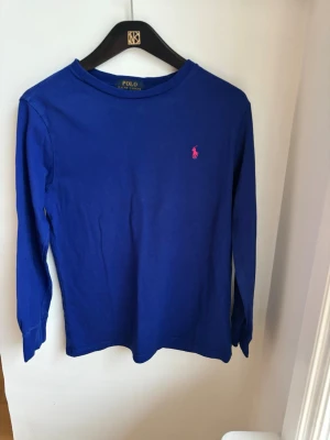 Polo Ralph Lauren tröja - En stilren blå långärmad Polo Ralph Lauren i st 10-12 år för endast 125kr. Nypris 800kr