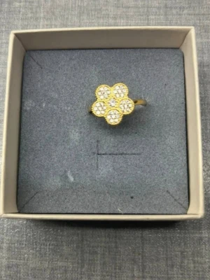 Guldplätterad ring i rostfritt stål NY - Vacker guldpläterad ring i rostfritt stål prydd med en blomma dekorerad med gnistrande kristaller. Perfekt för att addera en touch av elegans till din stil. Reglerbar storlek. Helt ny oanvänd. Nypris 299kr.