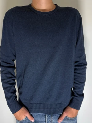 Mörkblå basic tröja från Jack & Jones - Tjeeena! Säljer nu denna från Jack & Jones. En enkel och stilren mörkblå stickad tröja med rund halsringning och långa ärmar. Tröjan har ribbade muddar vid ärmslut och nederkant. Storleken är från min bedömning stor S/liten M! Bara höra av dig om du har nån fråga. Tack på för hand MVH CarsliCloset 💙
