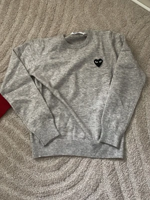 Grå stickad tröja Comme des Garçons - Grå stickad tröja från Comme des Garçons Play. den sitter tight och kort vid midjan och armarna