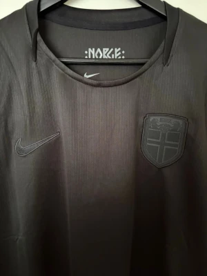 Svart Norge fotbollströja VM 2026 - Trendig Norge tröja, svart edition. Kommer med original förpackning, skriv om du har frågor!