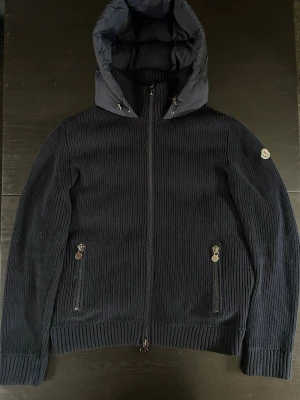 Moncler Maglione Tricot Cardigan - Moncler Maglione Tricot Cardigan i mörkblå storlek L. Mycket bra skick, NFC fungerar. Först till kvarn, skriv vid frågor 