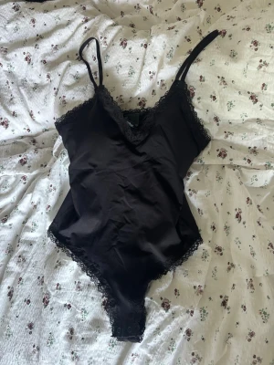 Svart spetsbody från H&M - Snygg svart body från H&M, jag säljer den pågrund av ingen användning! Det är aldrig använd 