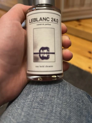 LEBLANC 24.0 One bold Chemist - LEBLANC 24.0 är en extrait de parfum i en stilren, genomskinlig glasflaska med silverfärgat lock. Etiketten är minimalistisk med svart text och en abstrakt illustration. Doften har noter av vanilj och äpple, vilket ger en unik och modern twist. Använt ett fåtal gånger ≈47ml kvar