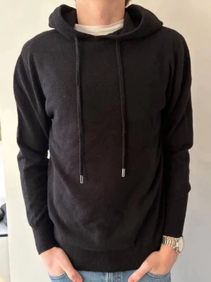 Bengtson’s 100% Merinoull Hoodie - Bengtson’s Merino | Helt Ny | Noir | 100% Merinoull | Storlek S | Handsydda Bengtson’s Tvättlappar | Modellen är 178 | Snören går att korta ner vid intresse!