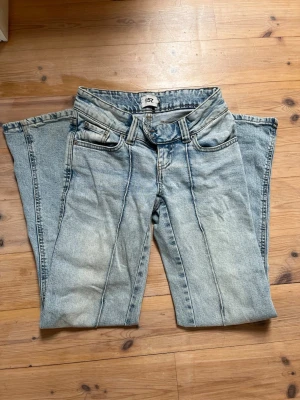 Lowaist och bootcut jeans  - Säljer ett par ljusblå jeans som är lågmidjade och bootcut. De har också ett jättecoolt stick längst fram. Jeansen är i storlek xxs men skulle säga att de sitter som xs. Jeansen är i modellen short. De är smutsiga längst ner (man ser på sista bilder). Skriv ifall fler frågor, pris går att diskutera!🩷🩷🩷