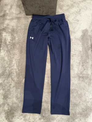 Blå träningsbyxor från Under Armour - Mörkblå träningsbyxor från Under Armour. Grymt skick!