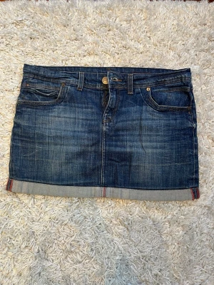 Jeanskjol - Superfin jeanskjol med lågmidja från Cross Jeanswear Co. Perfekt till sommaren och passar till alla outfits! Midjemått rakt över ca 43 cm & kjolen är 33 cm lång❤️