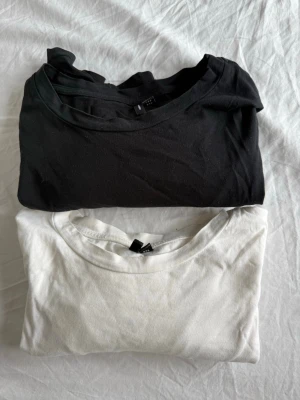 2-pack långärmade baströjor - Säljer två långärmade baströjor, en svart och en vit. Båda har rund halsringning och är tillverkade i mjuk bomull. Perfekta att styla lager på lager eller bära som de är. En är i S och den andra i M