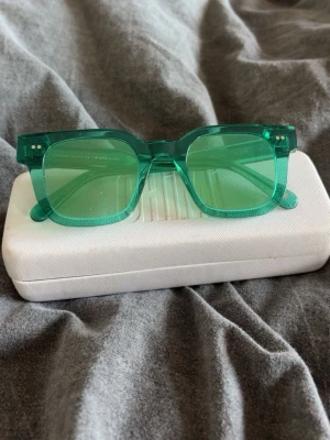 Chimi 04 - Säljer ett par stilrena solglasögon från Chimi i transparent grön färg. Modellen har en fyrkantig form och bågar i plast som ger en modern vibe. Perfekta för att lyfta din look under soliga dagar. Fodral ingår