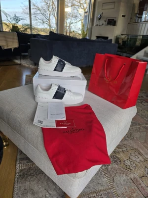 Valentino vita sneakers med blå detalj  - Snygga vita sneakers från Valentino med ett blåt streck över snörningen. Skorna är helt nya allt tillbehör finns kvitto också. Storlek 42