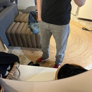 Grå raka jeans från jack & jones - Säljer ett par grå jeans från jack & jones med rak passform och klassisk femficksdesign. Jeansen har en snygg tvättad look och är tillverkade i bomull. Perfekta för en avslappnad och trendig stil.