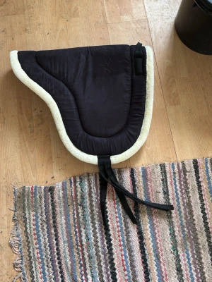 Barbackapadd  - Säljer en svart och vit barbacka padd i storlek one size men skulle säga att den passar ponny/ cob. Använt 3 gånger ändats.
