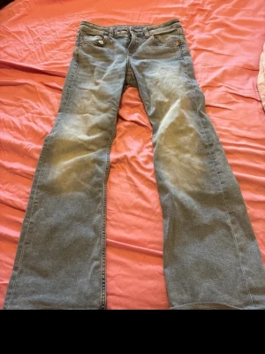 Ljusblå bootcut jeans - Säljer ett par ljusblå jeans med bootcut passform och klassisk femficksdesign. Jeansen har normal midja och är tillverkade i denim. Perfekta för dig som gillar en avslappnad och retro stil. Från h&m i storlek 38 säljer även dom på vinted 