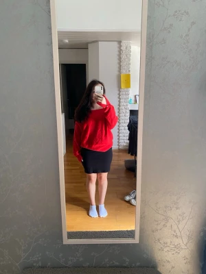 Röd off shoulder stickad tröja - Snygg röd stickad tröja med off shoulder-design och avslappnad passform. Tröjan har långa ärmar och bred ribbad kant vid halsen. Materialet ser mjukt och fluffigt ut, perfekt för dig som gillar en trendig och bekväm stil. Guld detaljer vid armarna, även slits vid armarna. Storlek M men passar även mindre storlekar. Använd men bra skick. 