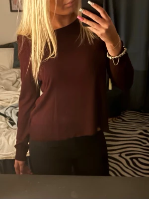 Mörkröd långärmad topp från Zara  - En enkel och stilren mörkröd långärmad topp med rund halsringning. Modellen är rak och något lös i passformen💗