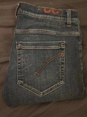 Blå skinny fit jeans från Dondup - Säljer ett par blå slim fit jeans från Dondup med klassisk femficksmodell och snygga kontrastsömmar. Jeansen har normal midja och raka ben, tillverkade i mjuk denim som sitter skönt hela dagen. Perfekta till sneakers eller boots. Priset kan diskuteras 😉