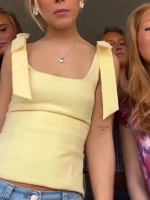 Gul linnetopp med knytband - Snygg ljusgul linnetopp med breda axelband som knyts i rosetter. Toppen har en figurnära passform och fyrkantig halsringning, perfekt för sommarens alla tillfällen 