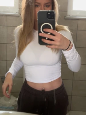 Vit tight långärmad  - Säljer en vit tight långärmad från Pull&Bear . Toppen är figurnära med rund halsringning och tillverkad i ett mjukt och stretchigt material. Perfekt att matcha med jeans eller kjol för en snygg look. Finns en liten fläck på baksidan av tröjan som ni ser på näst sista bilden, går säkert bort i tvätten men kan inte lova något. Toppen är i storlek Xs💞