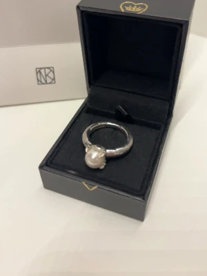 Silverring Maria Nilsdotter - Säljer min Claw Pearl-ring i 925 sterling silver med en sötvattenpärla. Det är ett mycket stilrent och vackert smycke som jag uppskattat, men som numera tyvärr mest blir liggande då jag inte använder det. Ringen införskaffades för cirka tre år sedan och är i fint skick, med endast obetydliga ytliga spår av användning. Kvitto finns dessvärre inte kvar, men vid seriöst intresse visar jag gärna bilder samt underlag som styrker äktheten.