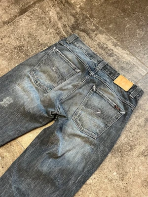 Vintage Nudie Jeans - Straight Sven - Tja! Nu säljer jag mina helt sjukt feta straight sven👏 de i strlk 33/34 men sitter mer som en 32/34 🫡 helt störda slitningar på dem som gör jeansen t dom perfekta straight/flared jeansen🖖 tveka inte på att skriva ifall du har några frågor🥹