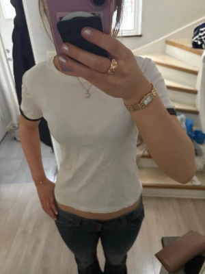 Fin T-shirt med detaljer  - Vit T-shirt med svarta detaljer på ärmarna med lite guld glitter 