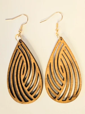 Bruna träörhängen från Trossel - Säljer ett par coola örhängen i brunt trä med droppform och snyggt laserskuret mönster. De har krokar i metall och är lätta att bära. Perfekt för dig som gillar unika accessoarer med naturlig vibe. Eleganta örhängen med en kombination av trä och bladmotiv.  Perfekt för att komplettera din stil med en naturlig och bohemisk touch.  Trädelen är ca 5 cm lång. Motivet är fäst på högkvalitativa örhänges-krokar i rostfritt stål.  Nya med etikett.